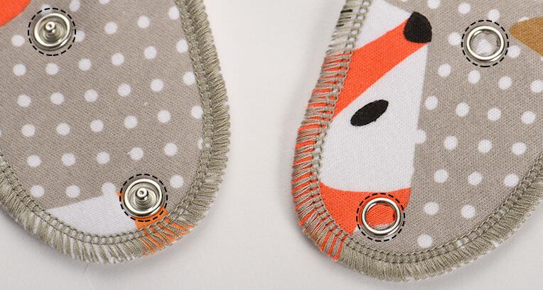 Set of 4 Nova Mart baby bibs and burp cloths with arrow, wave, and triangle prints, made of soft cotton bandana fabric.