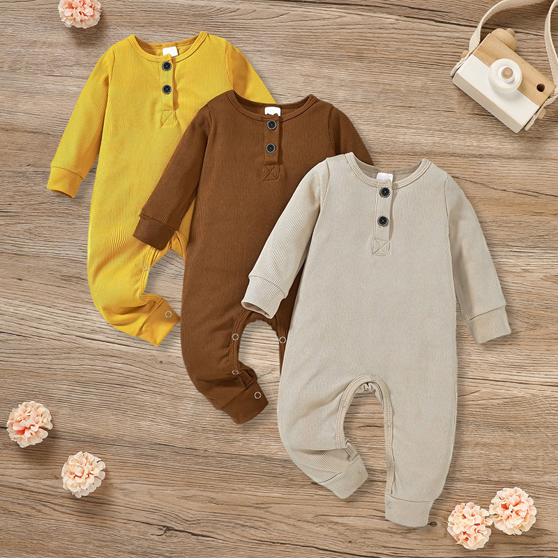 Three newborn baby boys and girls in soft, ribbed long sleeve rompers with button fronts, showcasing Nova Mart jumpsuits.