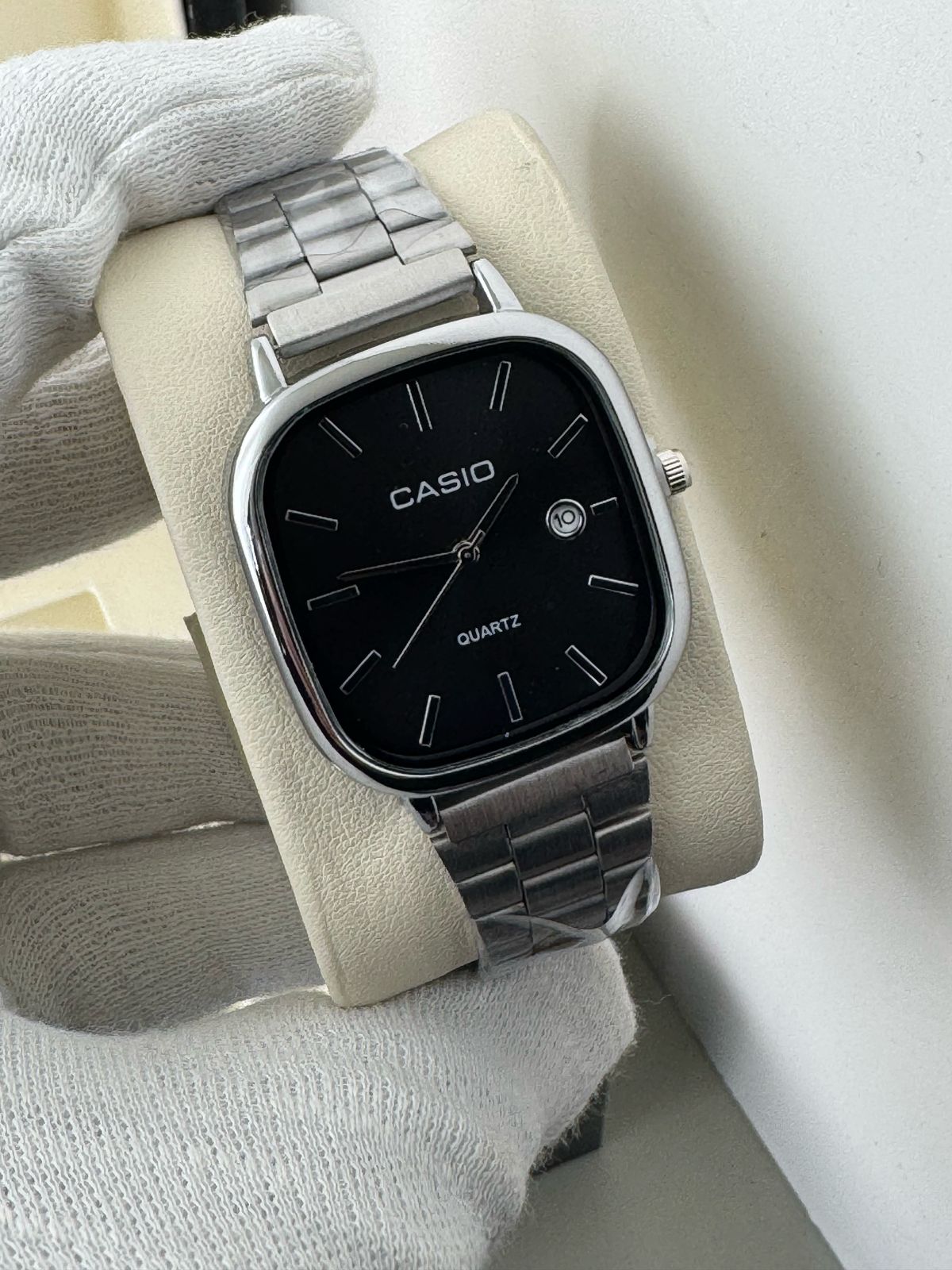 Casio watch with black face and silver metal strap on a white background