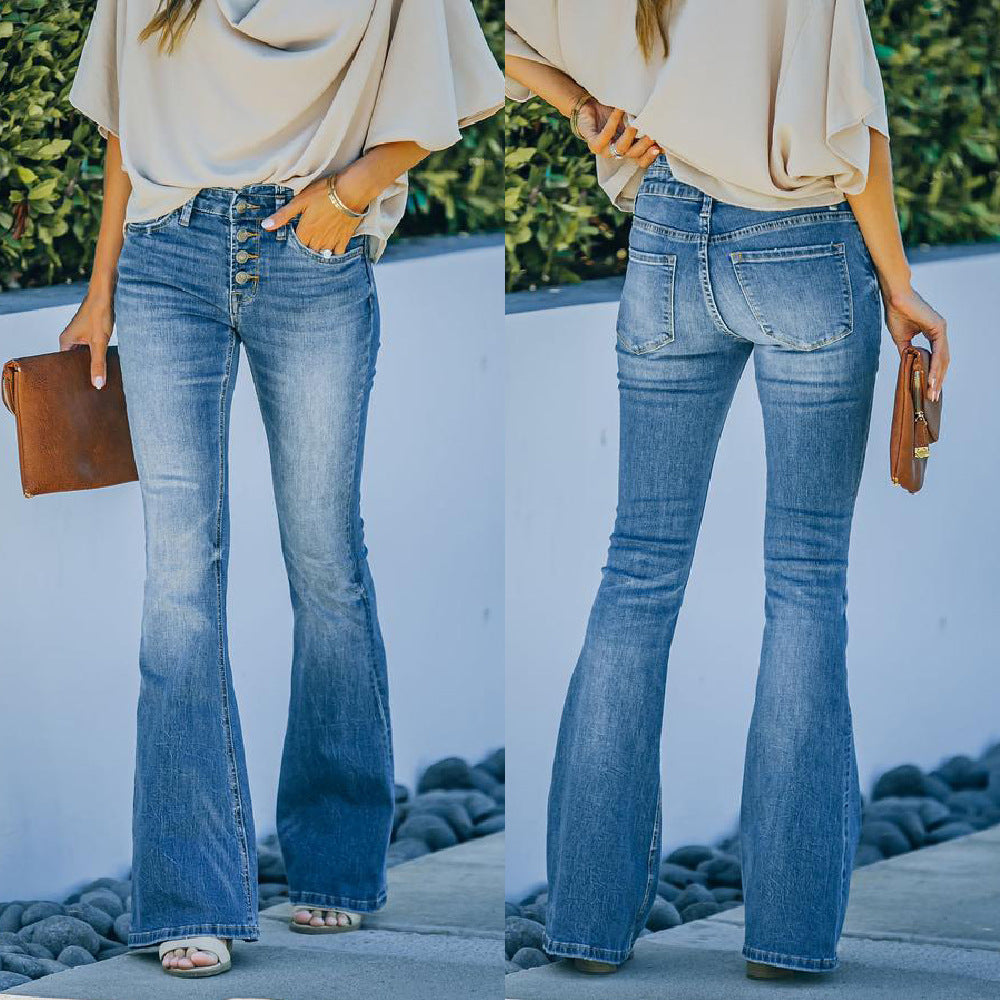 Women wearing flared jeans with a neutral top and brown clutch against a white wall.