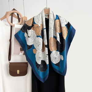 Blue scarf with animal pattern draped over a black garment on a white background