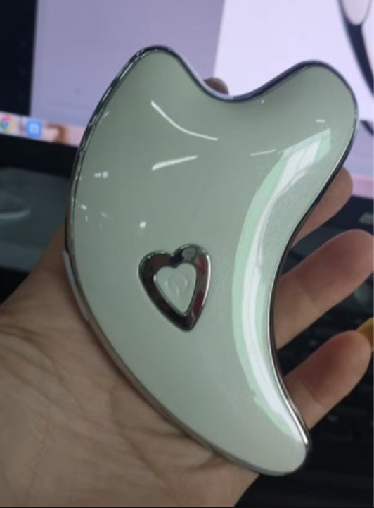 Green jade-like object with a heart-shaped cutout held in a hand.