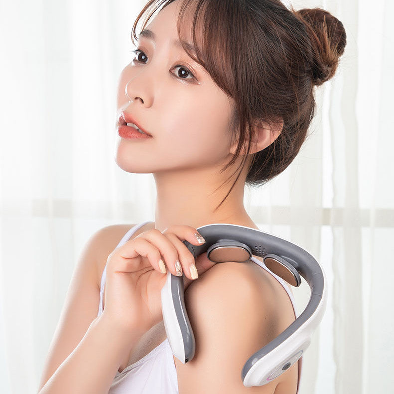 Woman using a neck and shoulder massager against a white curtain background