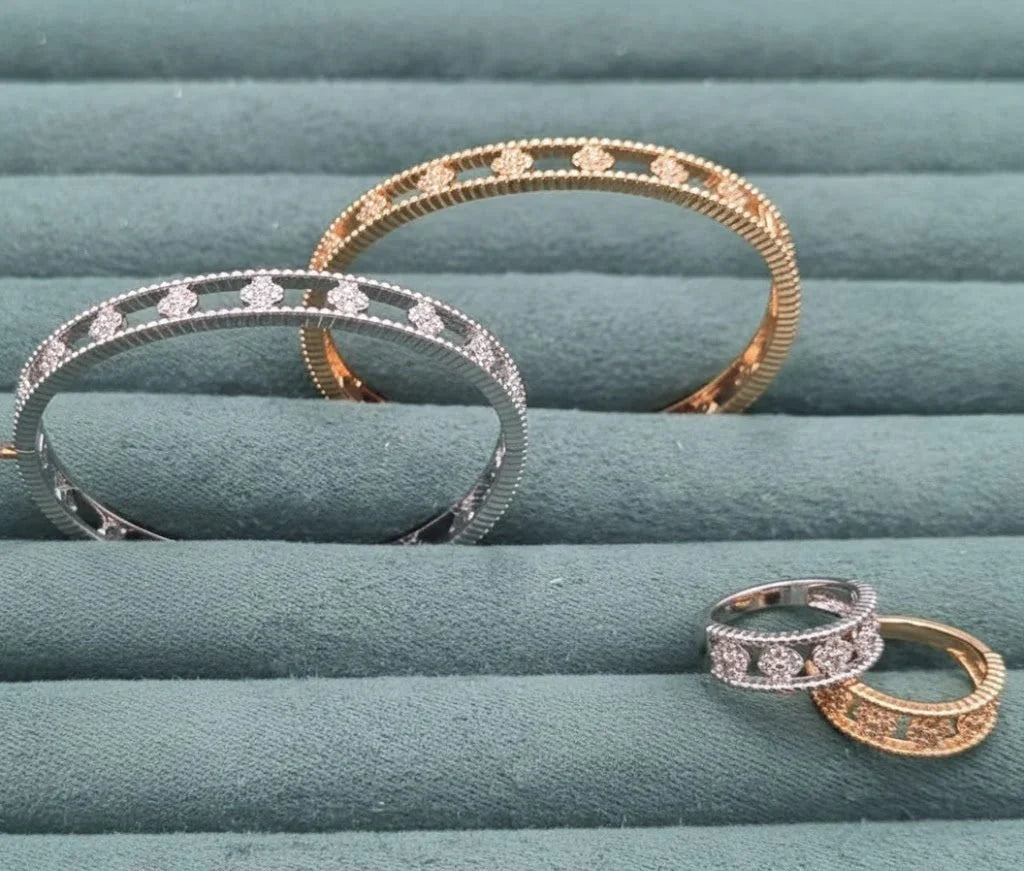 Two bracelets and two rings on a textured green surface