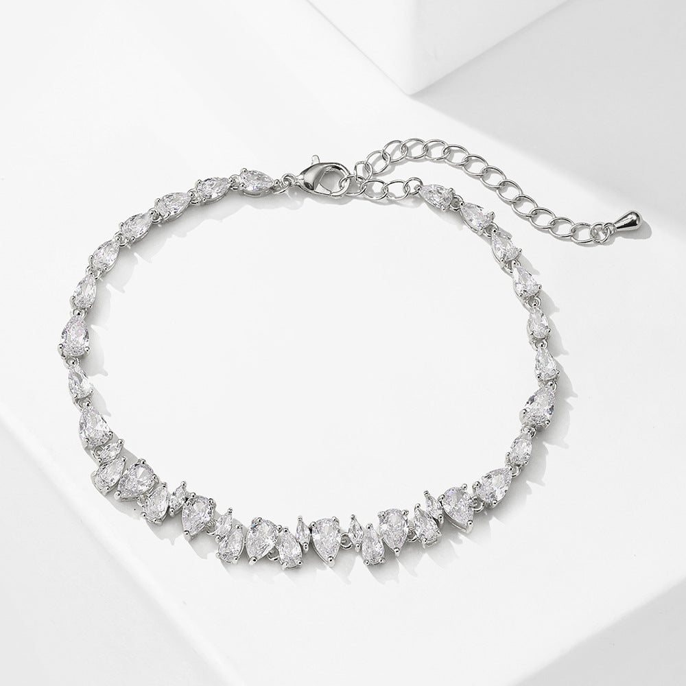 Silver bracelet with clear gemstones on a white background