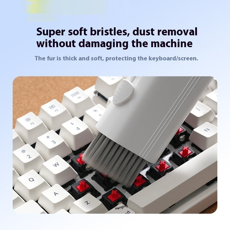 Keyboard cleaning brush being used on a keyboard with text about soft bristles and dust removal.