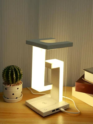 Modern LED desk lamp on a wooden surface with a cactus and books in the background.