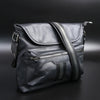 Black leather bag with zippers on a dark background