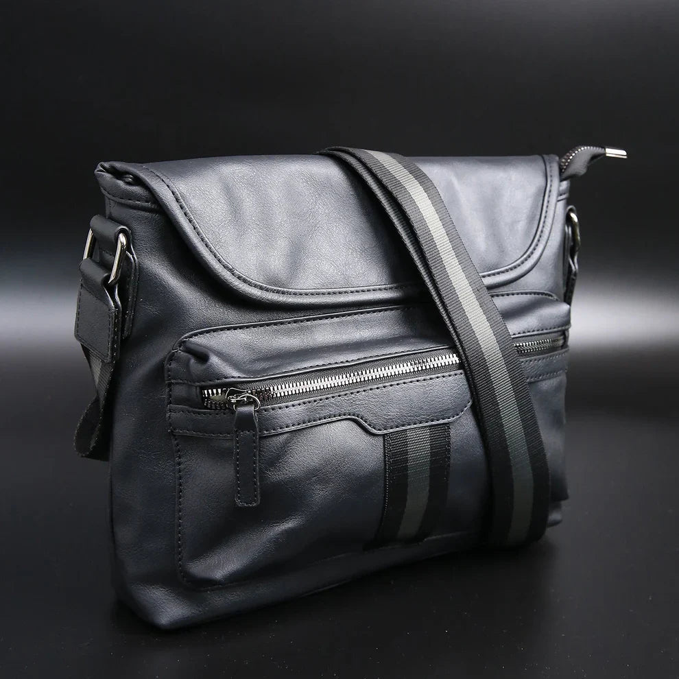 Black leather bag with zippers on a dark background