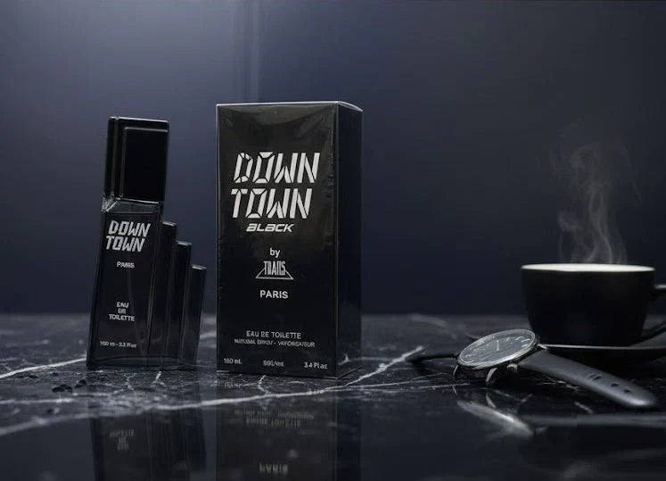 Down Town Black perfume bottle and packaging on a dark surface with a watch and cup in the background.