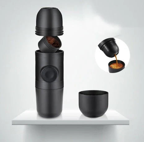 Black portable coffee maker with a cup on a white shelf