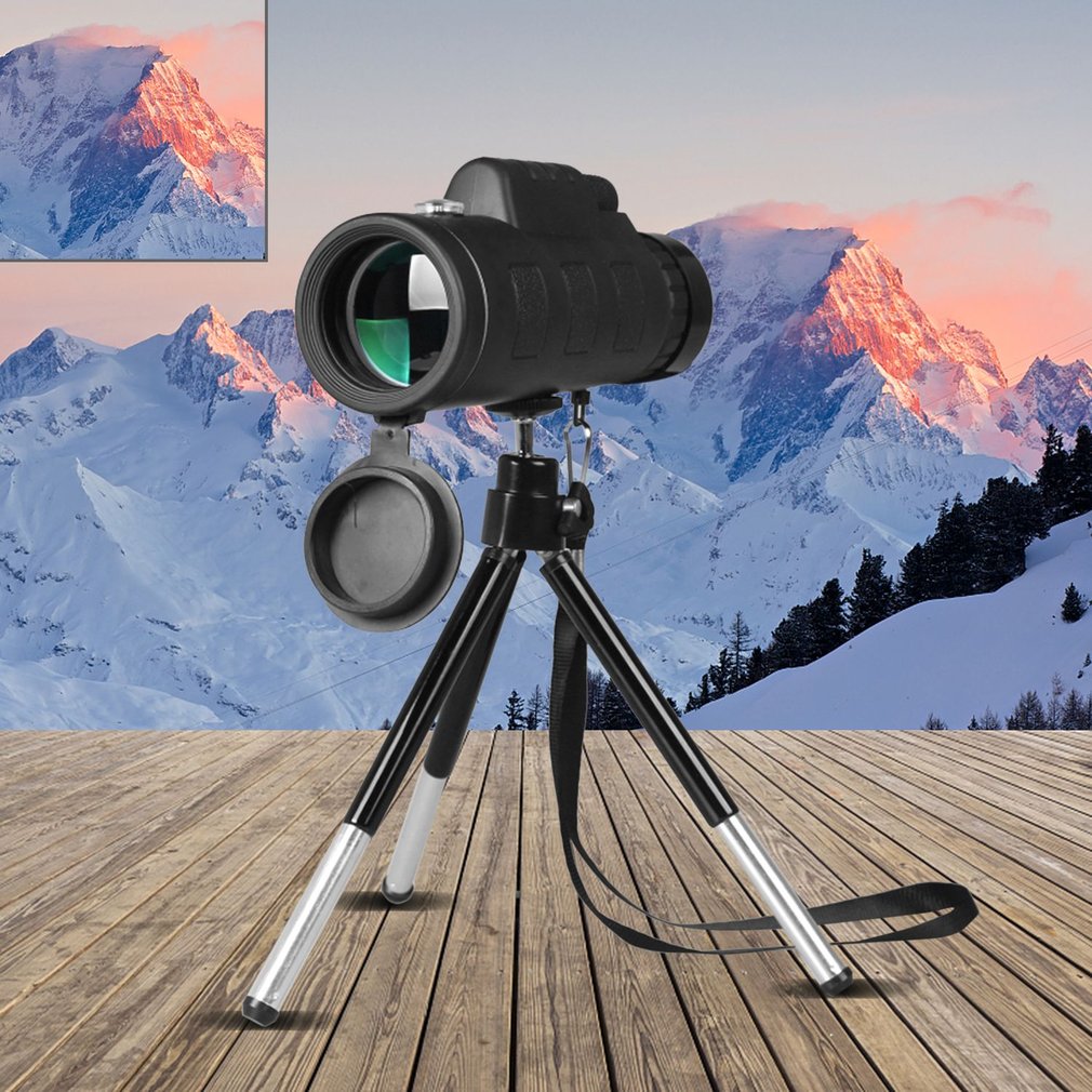Monocular telescope on a tripod with a mountainous landscape in the background
