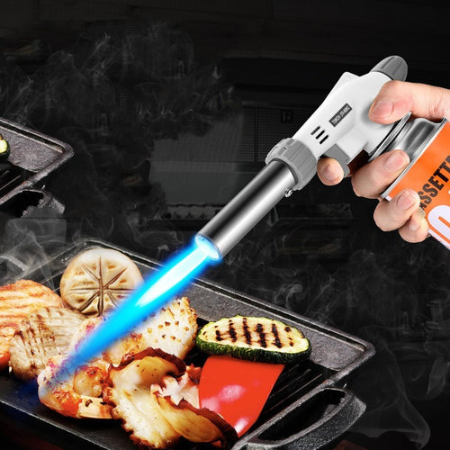 Butane torch being used to cook food on a grill with a dark background