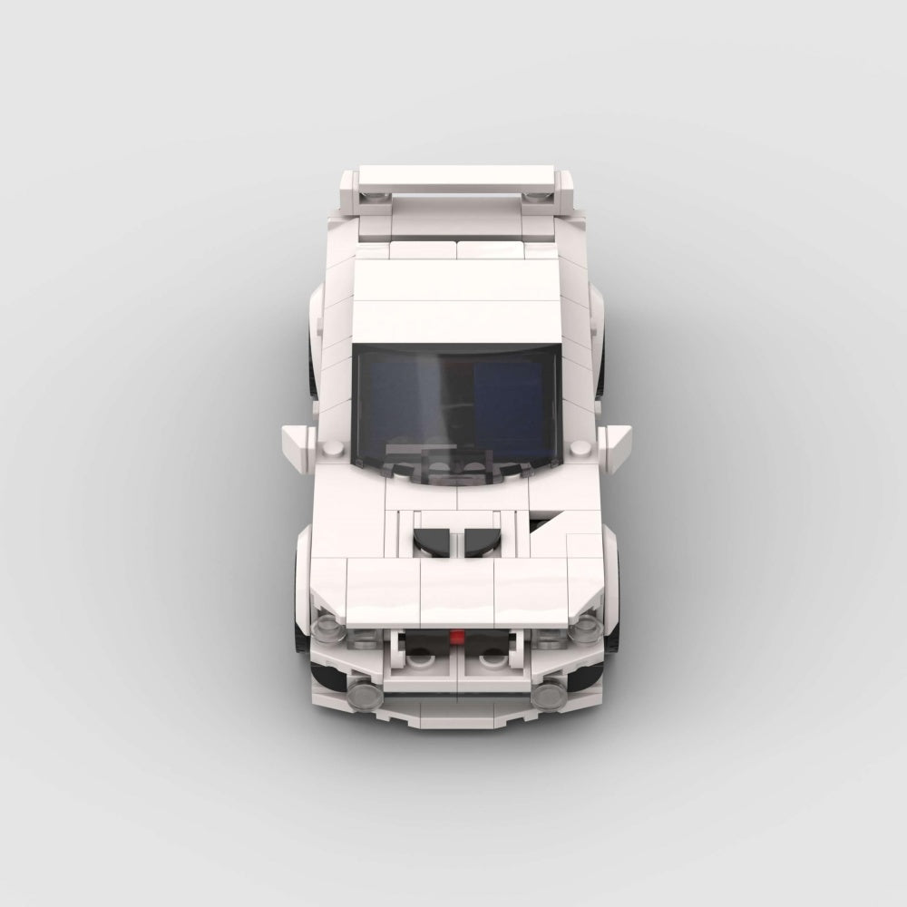 Top-down view of a white car model made from interlocking bricks on a light gray background