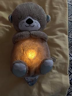 Plush teddy bear with a glowing light inside on a beige surface