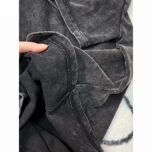 Close-up of a dark gray textured fabric with a hand holding it.