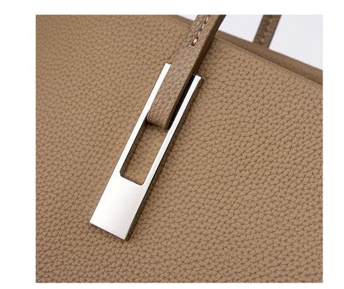 Close-up of a beige textured bag with a silver clasp on a white background