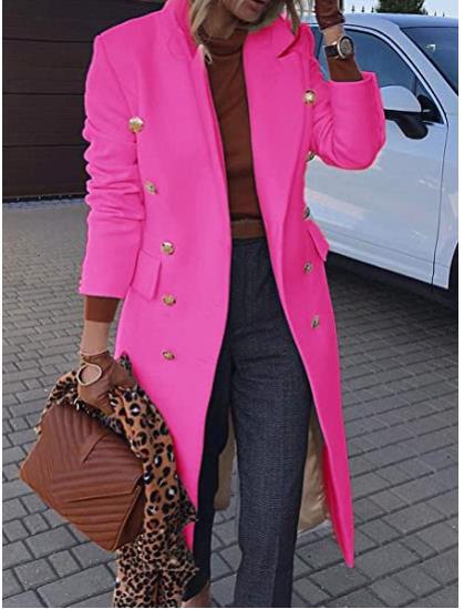 Person wearing a bright pink coat with gold buttons, standing on a street.