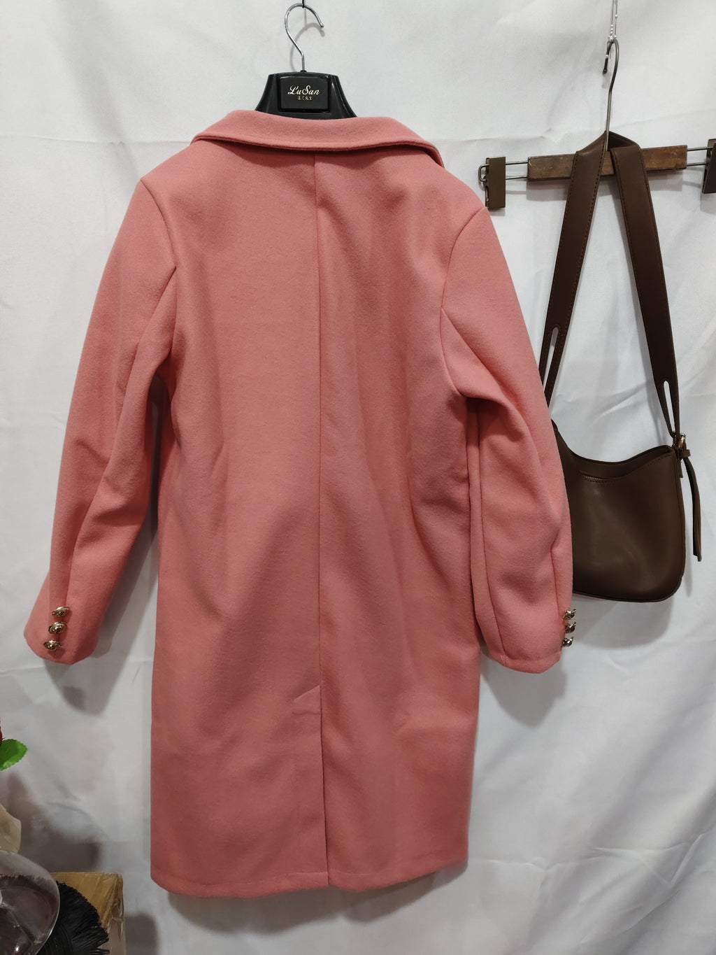 Pink coat on a hanger against a white background